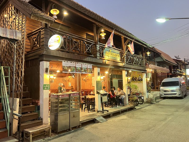 หน้าร้านเรือนไม้เปิดไฟยามโพล้เพล้ในซอย